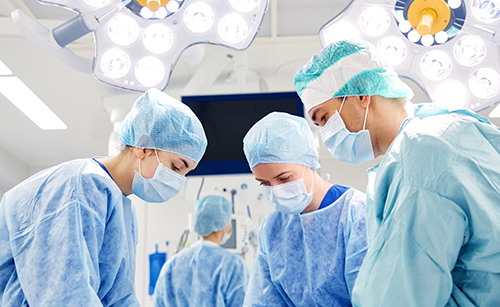 surgery, medicine and people concept - group of surgeons at operation in operating room at hospital